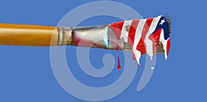 An artistÃ¢â¬â¢s paint brush drips with the red, white and blue of an American flag photo